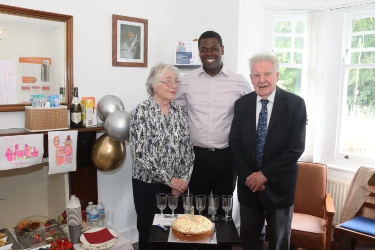 A table set with a birthday cake and glasses ready for a toast.