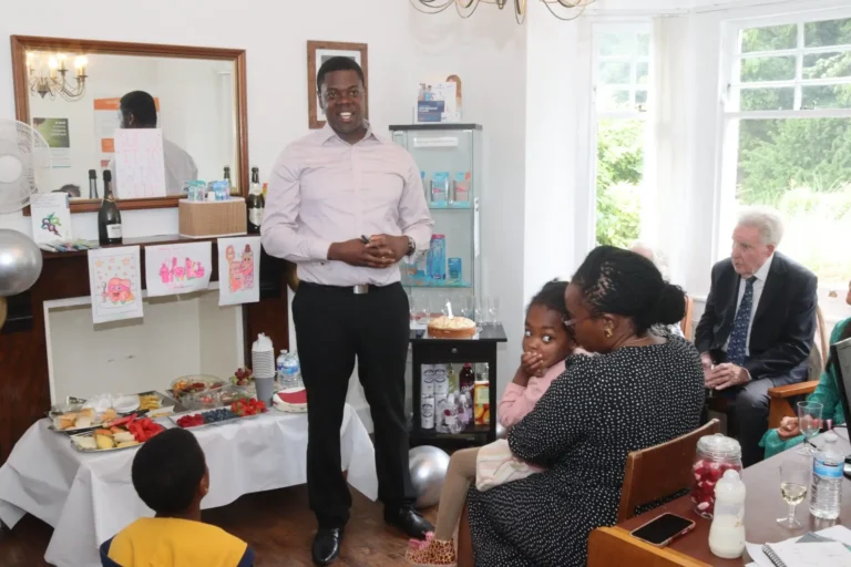 Dr. Tobi at a celebration event surrounded by family and friends.